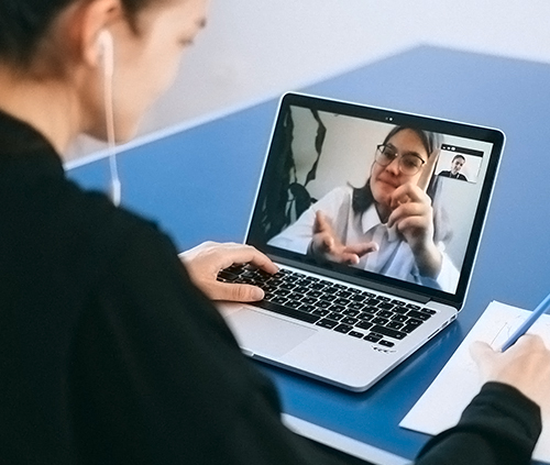 Estudiante de secundaria tomando una clase online con los auriculares puestos imagen