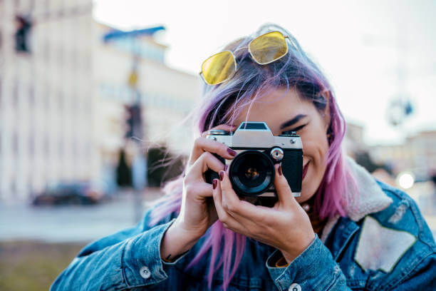 Una chica haciéndose una foto con su cámara